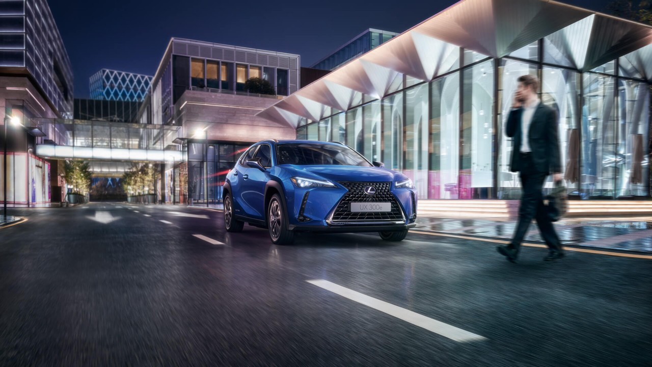 A Lexus UX 300e driving in a city location 