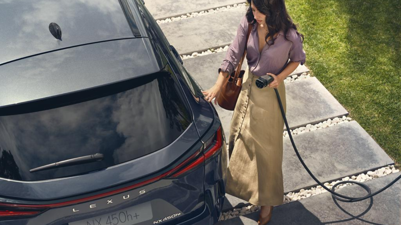 A person plugging in a charging socket into a Lexus NX